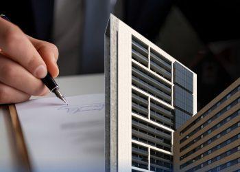 Close-up of a hand signing a document with a miniature modern skyscraper model in the foreground, implying real estate or architecture contracts.